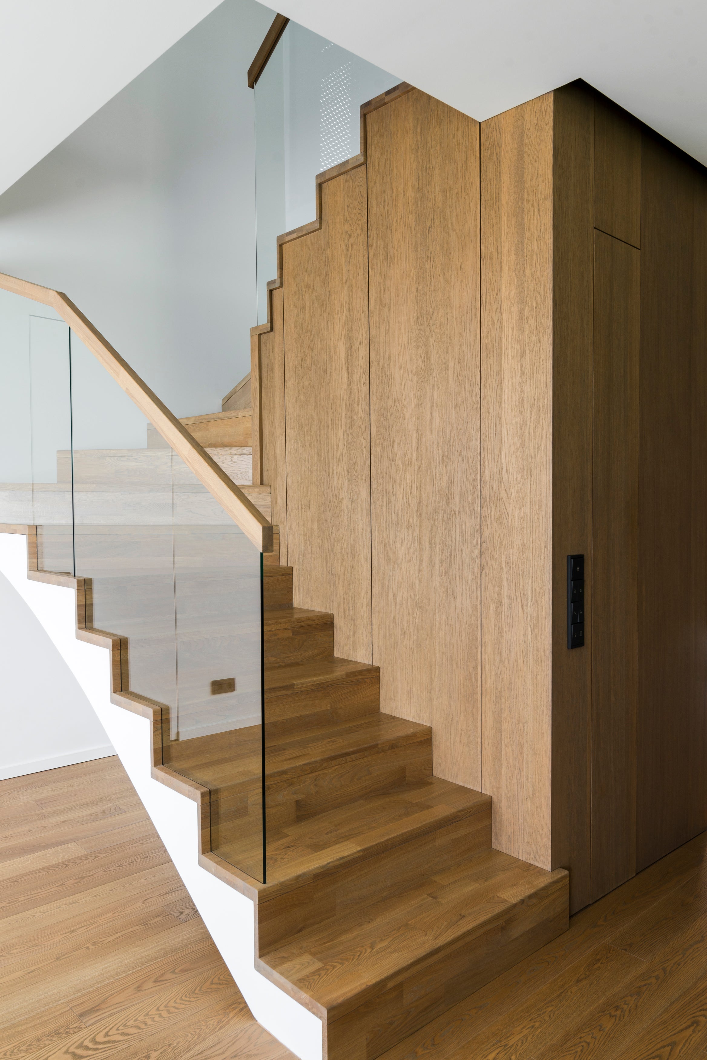 Moderne Holztreppe und Wandverkleidung, versiegelt mit strapazierfähigem Remmers Treppen- & Parkettlack.